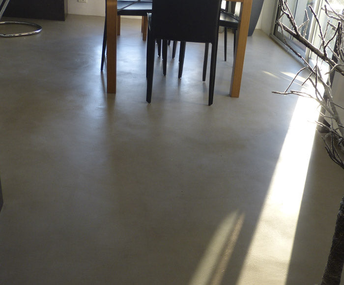 Sol décoratif gris dans une pièce à vivre avec espace repas